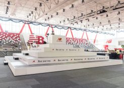 Custom riser pyramid with while fascia and New Balance logos around it, inside the center of The Track at New Balance in Boston, MA