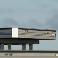 a single uni-dec sitting on a base on top of a stage. blue sky behind it.