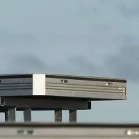 a single uni-dec sitting on a base on top of a stage. blue sky behind it.