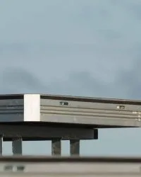 a single uni-dec sitting on a base on top of a stage. blue sky behind it.