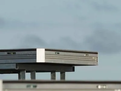 a single uni-dec sitting on a base on top of a stage. blue sky behind it.
