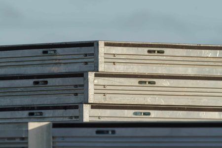 Close up of a stack of three unidec on top of a uni-dec stage. outdoors. light blue sky. no clouds. sunset colored sun hitting one side o fthe unidec stack