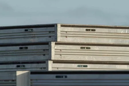 Close up of a stack of three unidec on top of a uni-dec stage. outdoors. light blue sky. no clouds. sunset colored sun hitting one side o fthe unidec stack